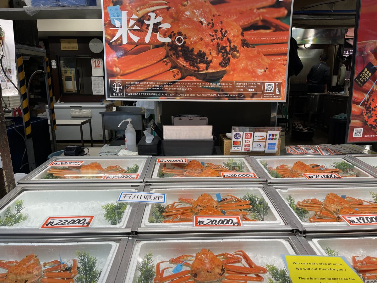 近江町市場:カニの販売。香箱ガニが並べられており、値段が表示されている。