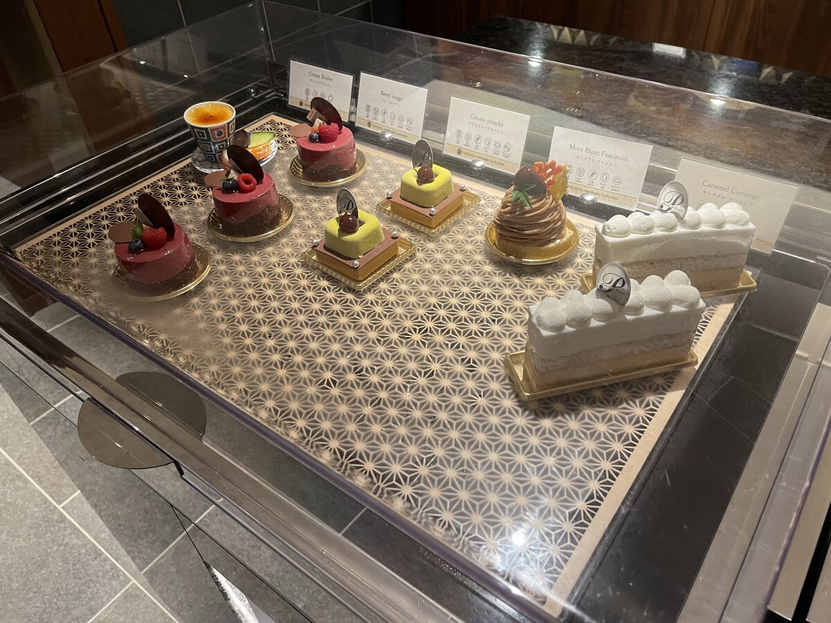 THE HOTEL SANRAKU KANAZAWA：建物外観と庭園。水盤があり、テーブル席が見える。