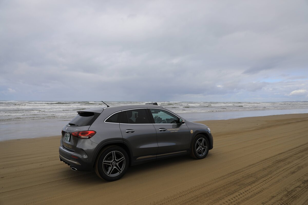 車の窓から見える砂浜と海