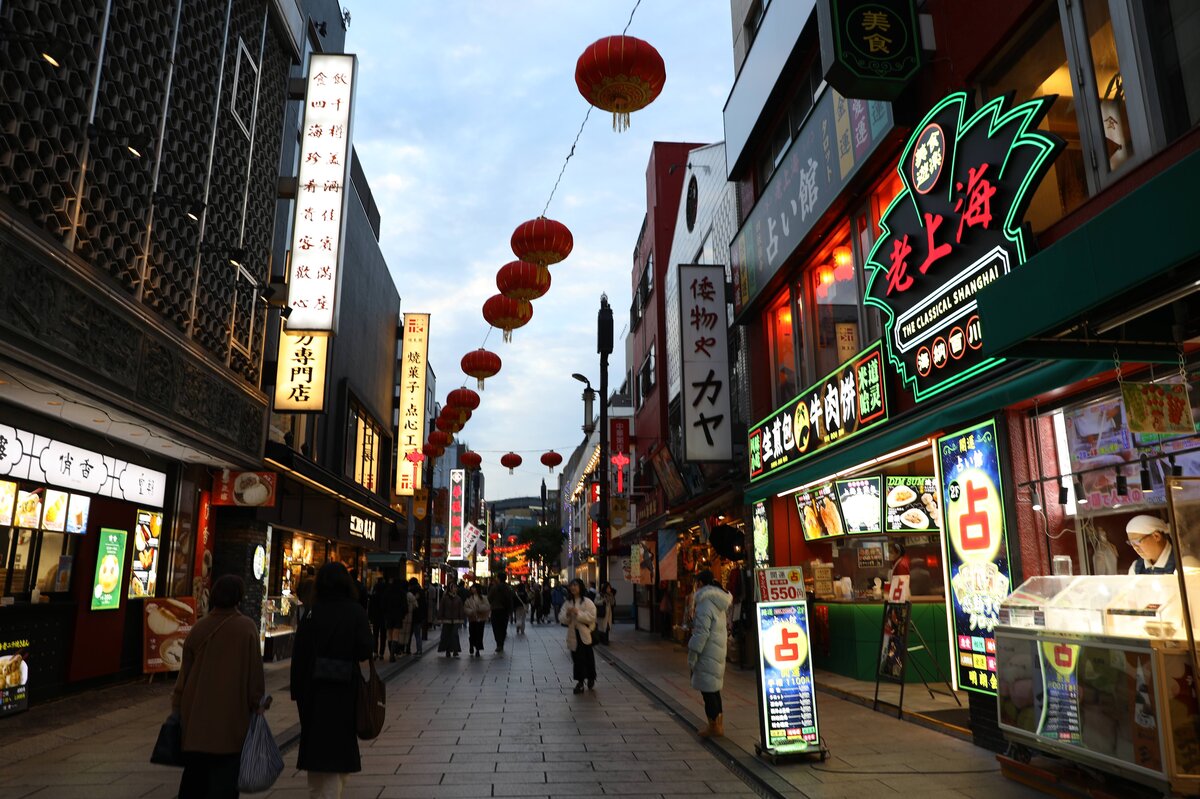 重慶飯店　中華街：街の風景。複数の飲食店があり、人々が歩いている。