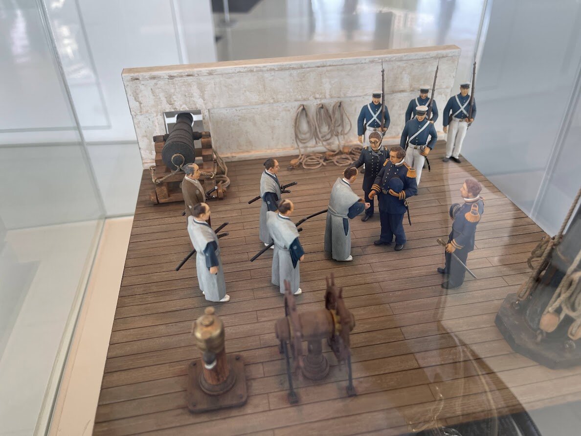 坂道の風景。海と街並みが見える。