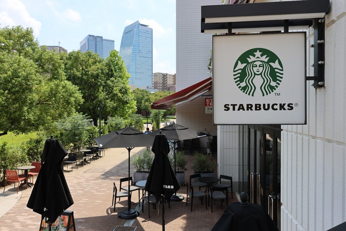 スターバックス コーヒー 名古屋則武新町1階店：スターバックスの看板と屋外のテーブル席