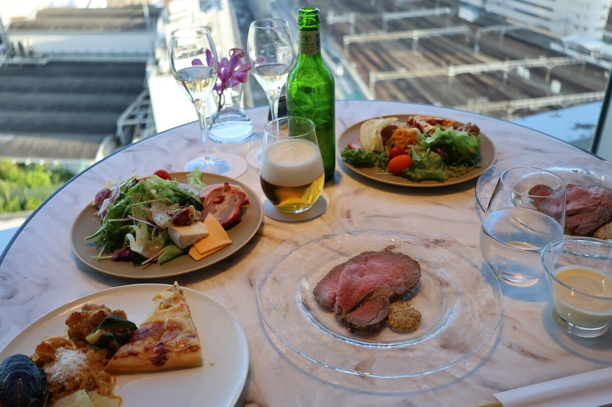 名古屋マリオットアソシアホテル：テーブルに並んだサラダ、ローストビーフ、ピザ、ワインなど...