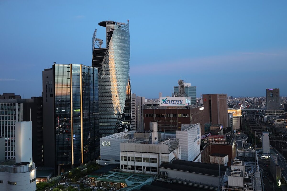 名古屋マリオットアソシアホテル：夕暮れ時の名古屋駅周辺の風景。高層ビル群が並ぶ。