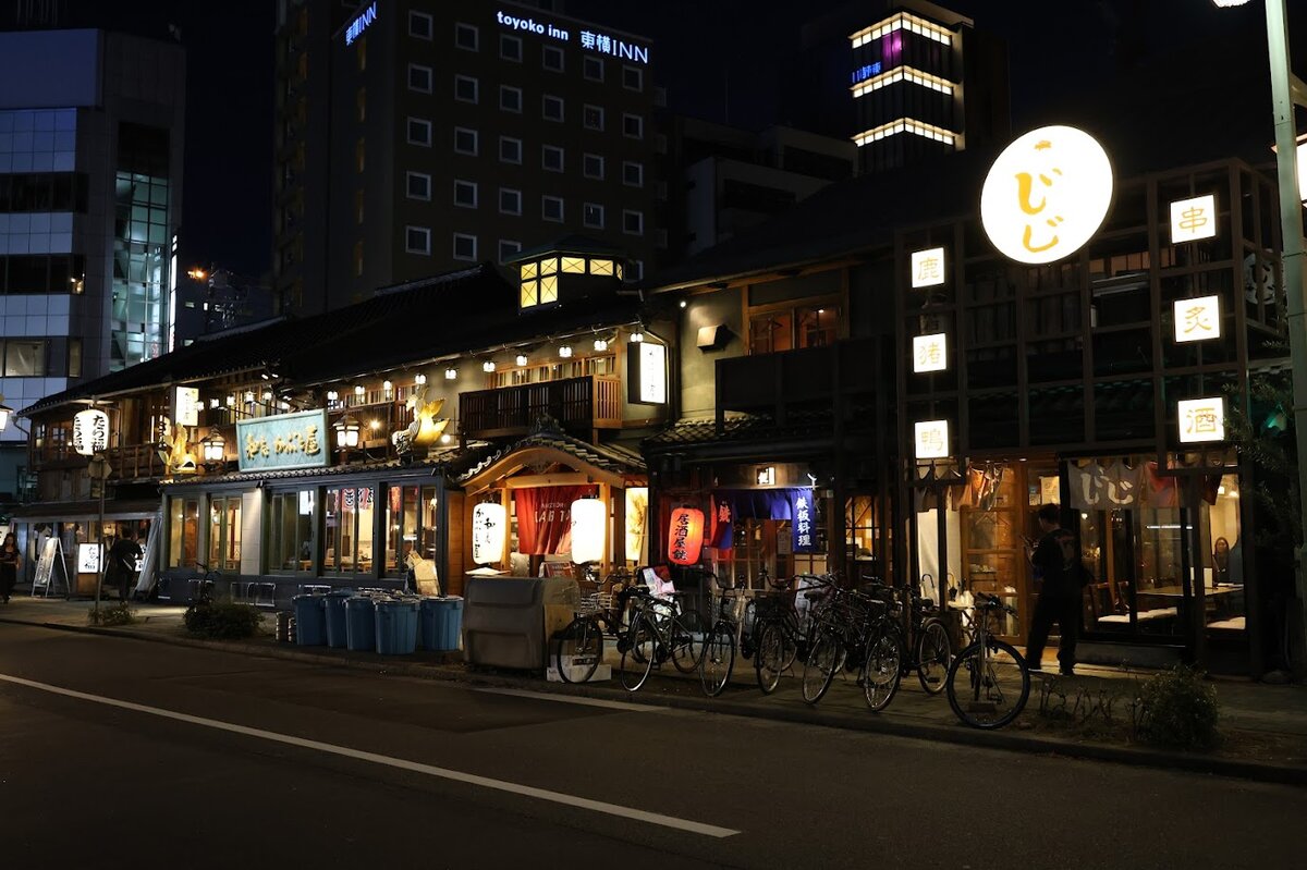 じ, 炙, たら福, toyoko inn 東横INN：夜の街並み。複数の飲食店やホテルが写っている。