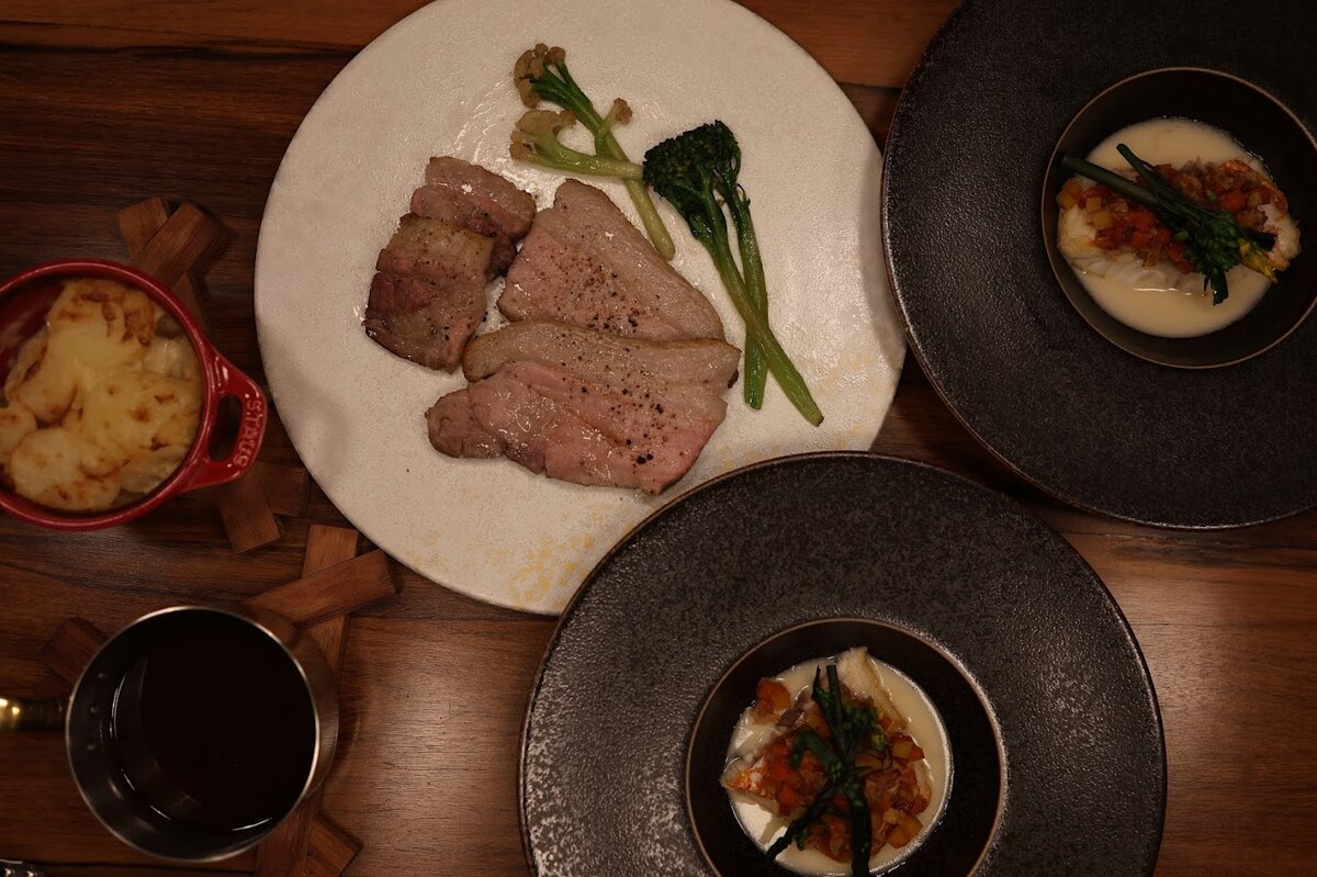 UMITO 熱海 別邸：豚肉料理にソースをかけている　お部屋でいただくフレンチコ...