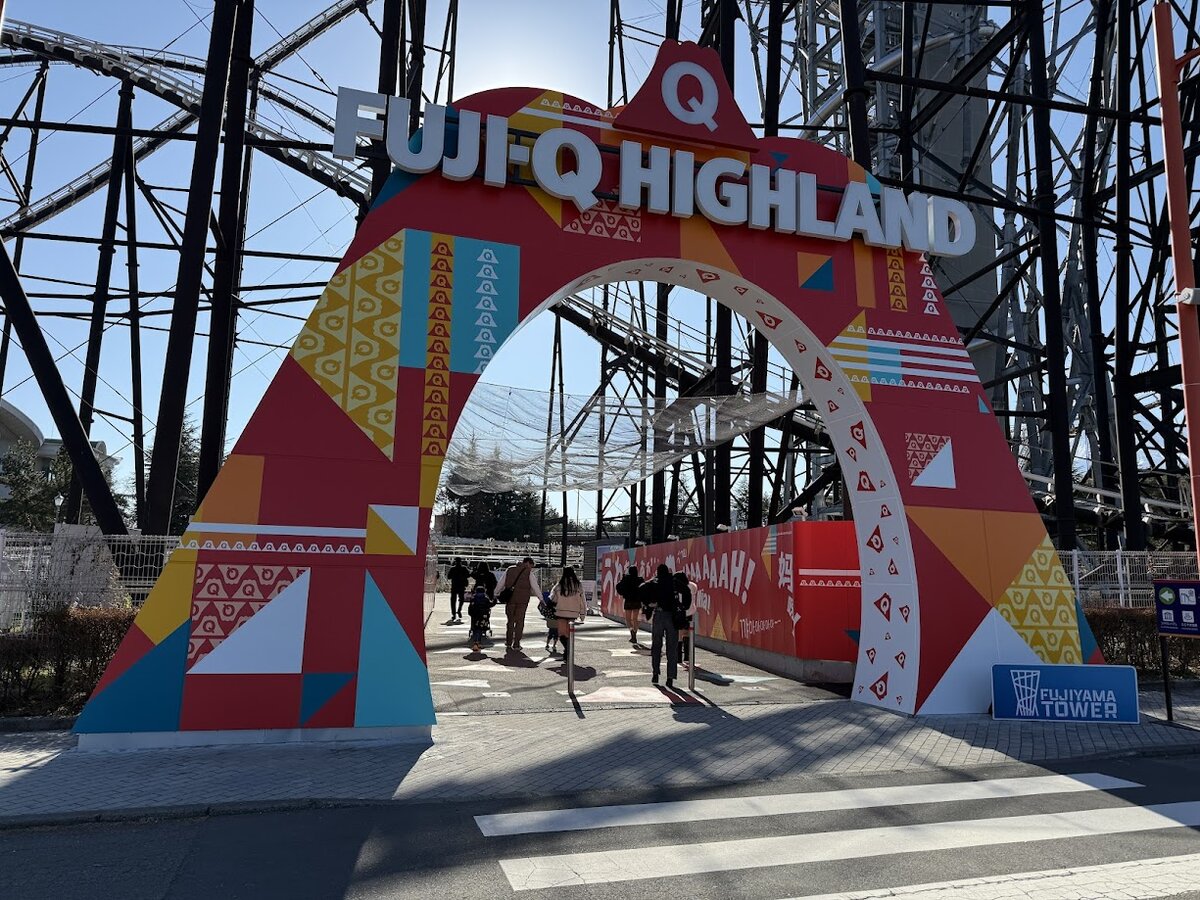 FUJI-Q HIGHLAND：富士急ハイランドの入り口の看板と、周辺を歩く人々。
