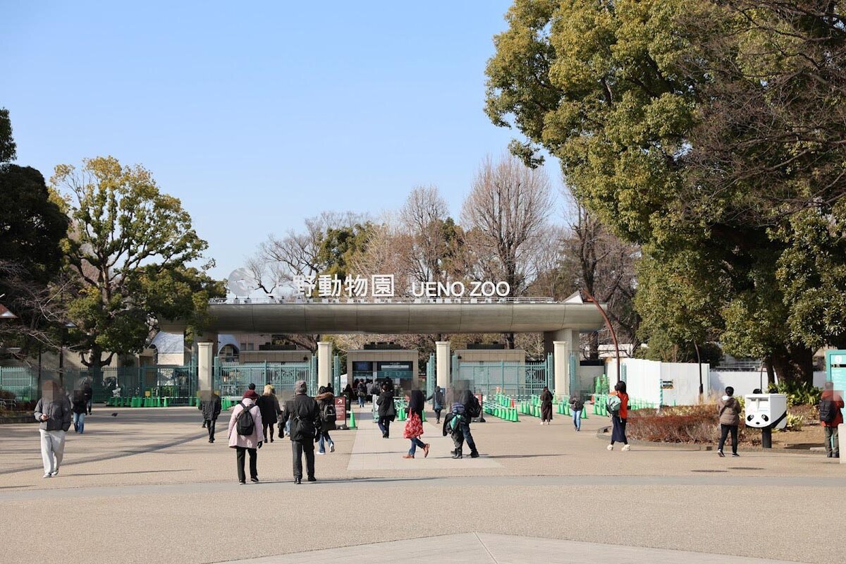 上野動物園 UENO ZOO：上野動物園の入り口付近の写真。人が複数写っている。