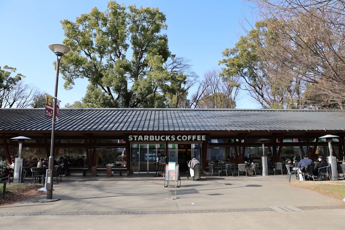 スターバックスコーヒー上野恩賜公園店：スターバックスコーヒーの外観。人々が座っている。