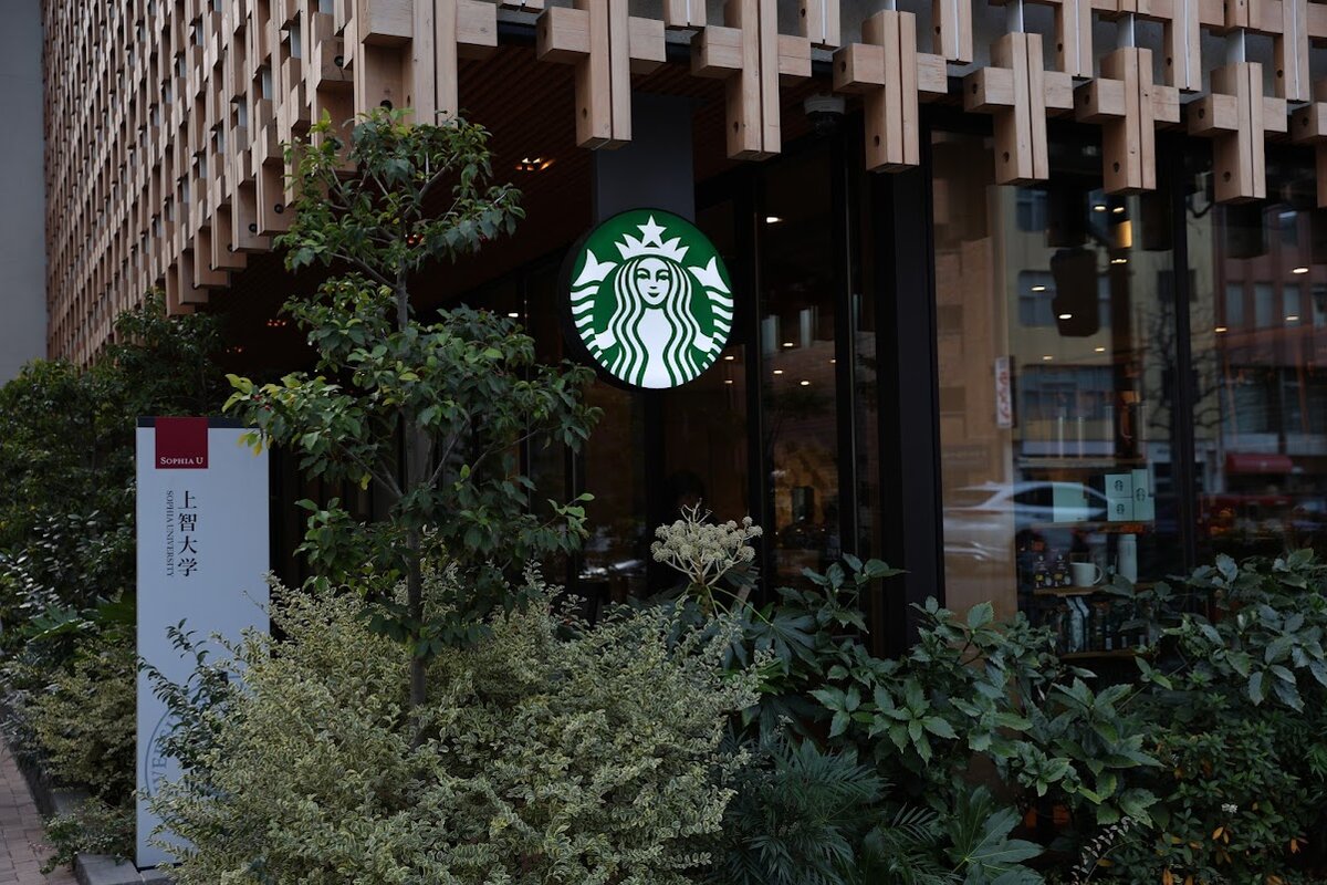 スターバックス コーヒー 上智大学 四谷キャンパス店：木製の格子状の外観のスターバックスがある街並み
