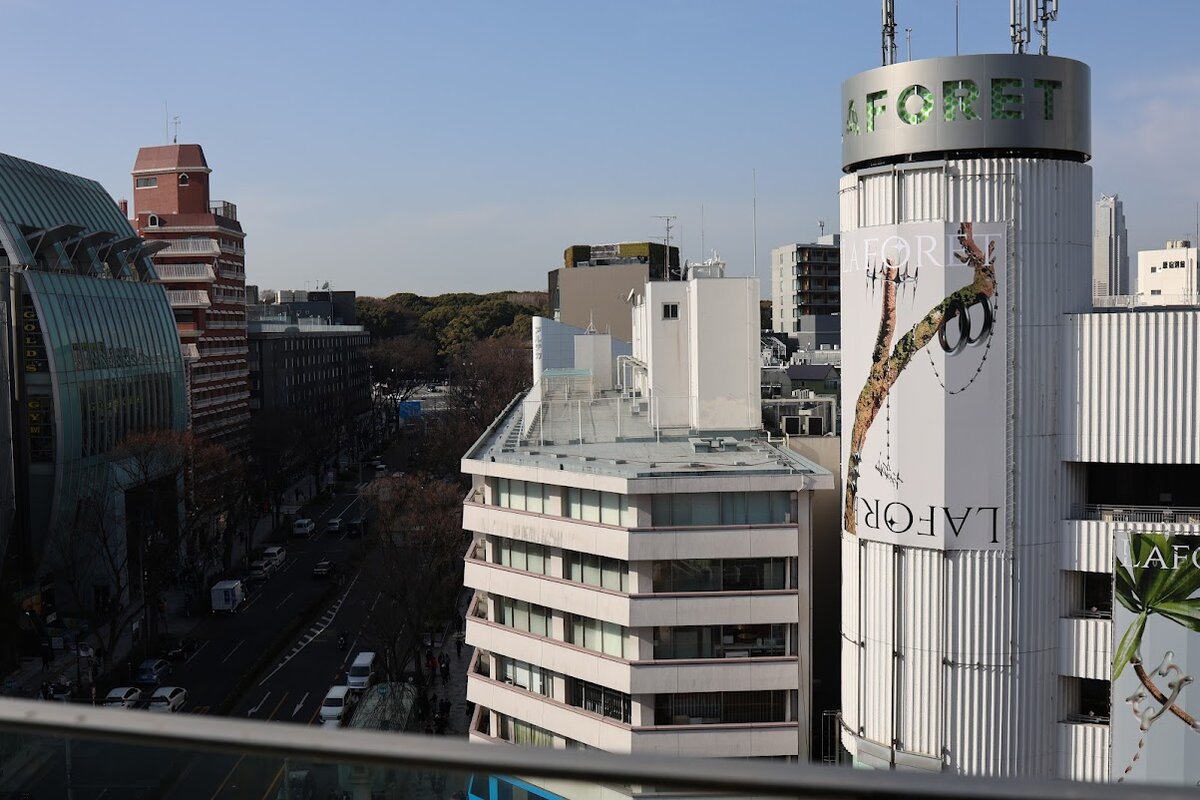 DIOR：ガラス張りの特徴的な外観の建物。一部は緑化されている。道...