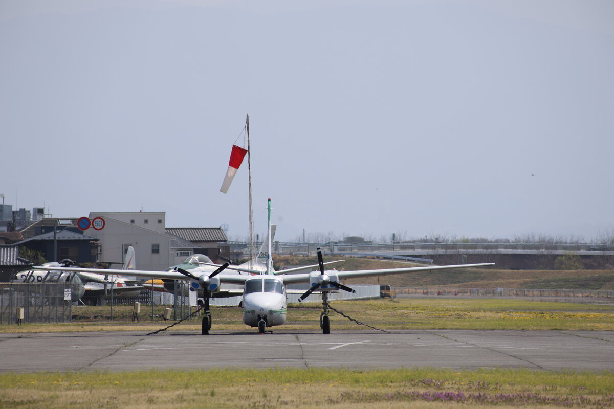 日本航空学園：空港の風景。飛行機、建物、滑走路が見える。