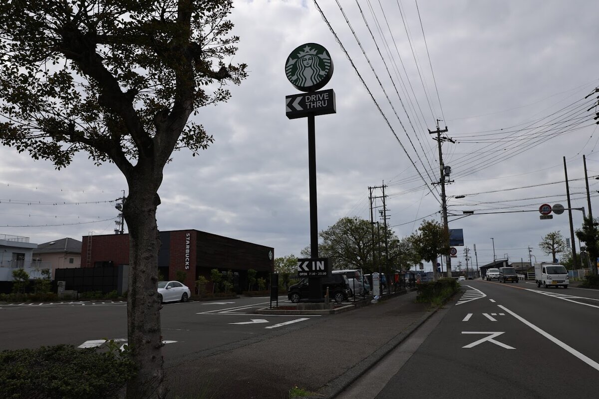 由比PA (下り)：海岸沿いの道路と白い車
